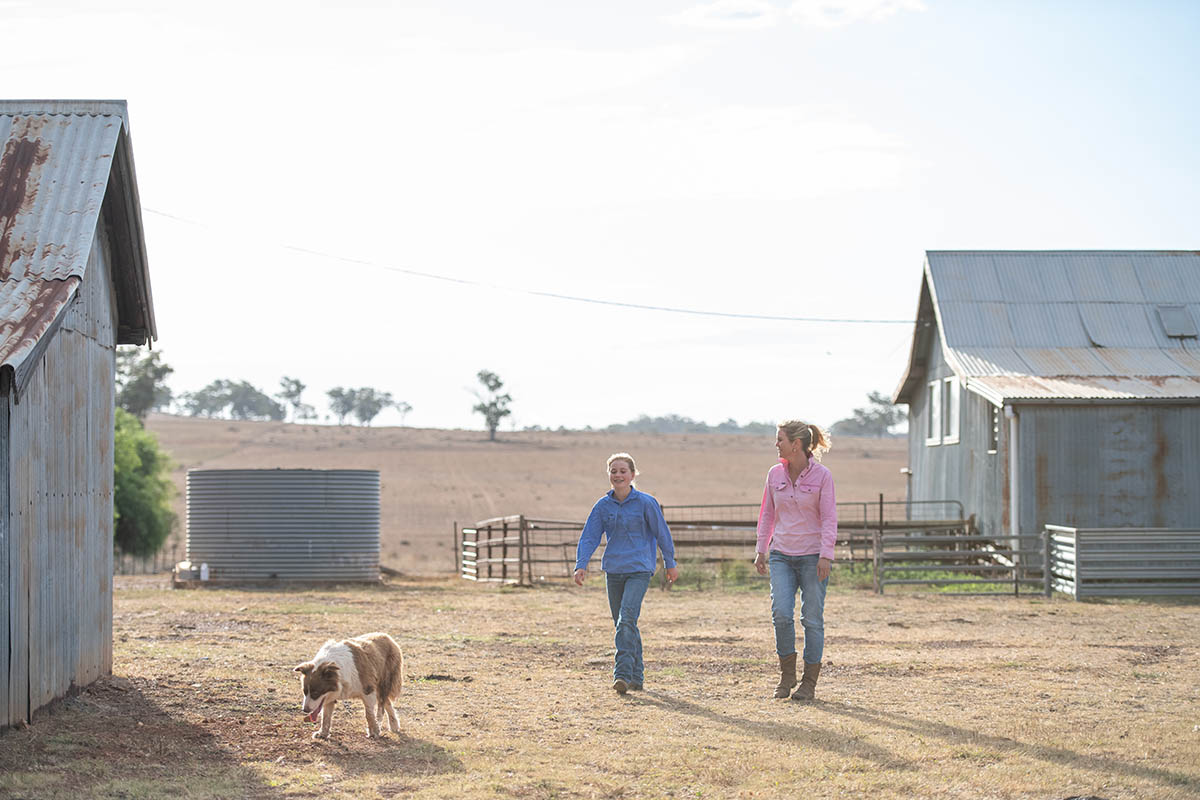 Female farmer, daughter and dog walking