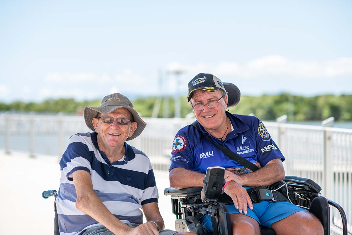 Two men in wheelchairs on boat pier