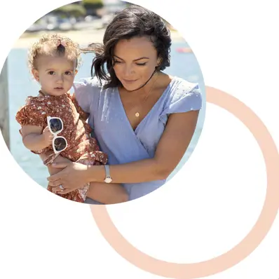 Woman carrying baby on a beach