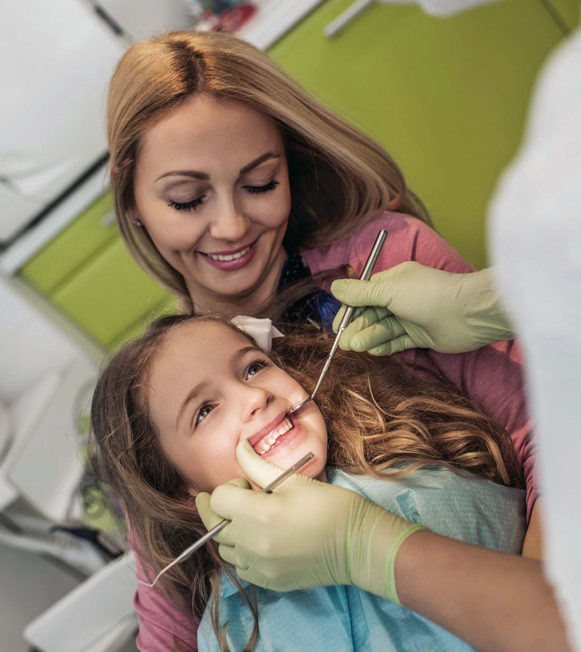 Young girl at dentist with mum