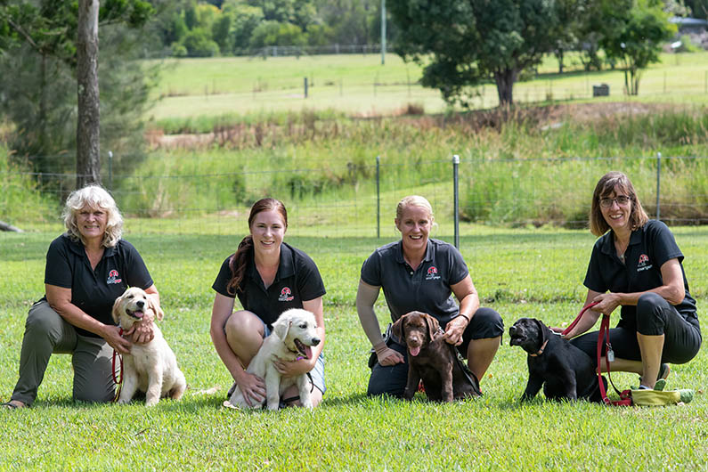 Four women with four puppies