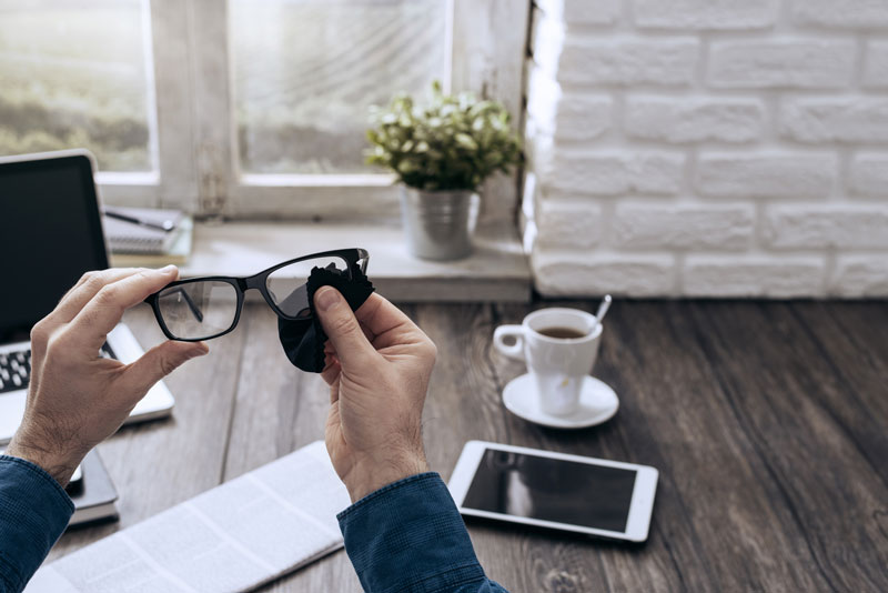 Person cleaning eye glasses