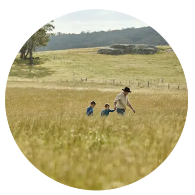 man and two children walking in wheat field