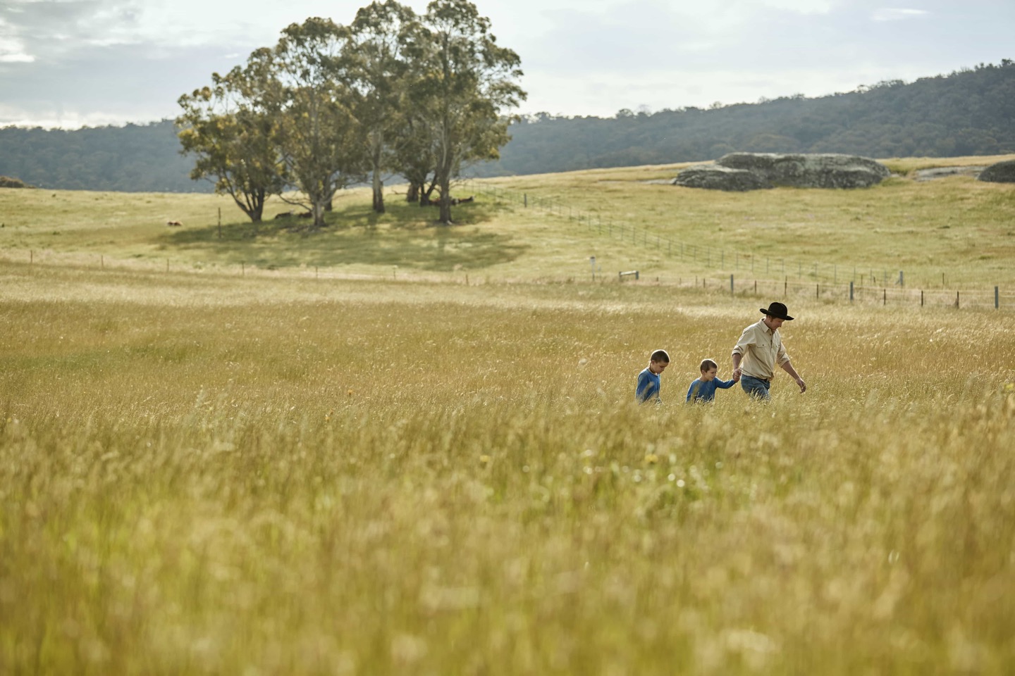 man and two children in field
