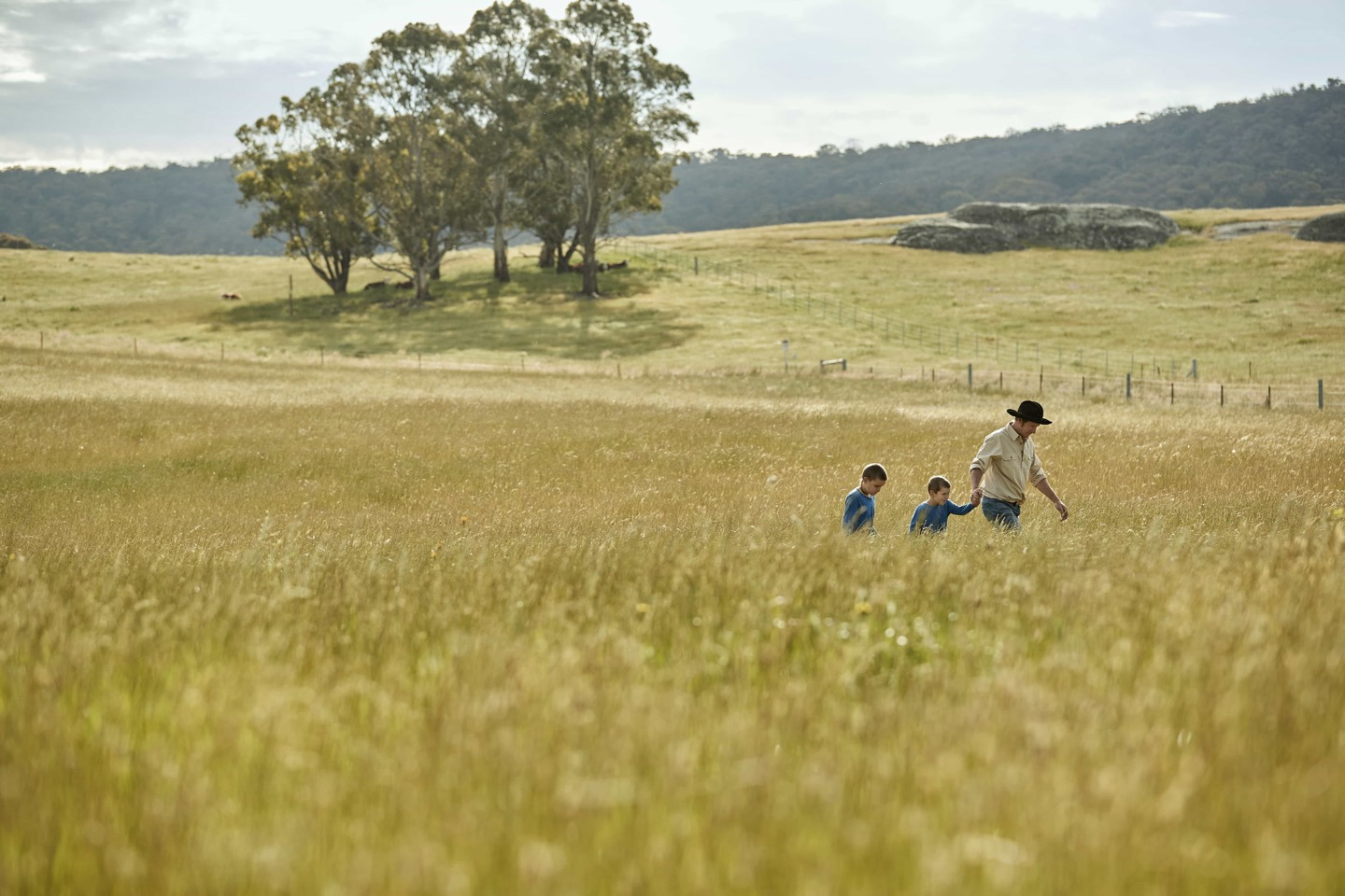 Man and two children walking in Austalian field