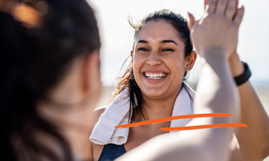 Smiling woman exercising with another woman