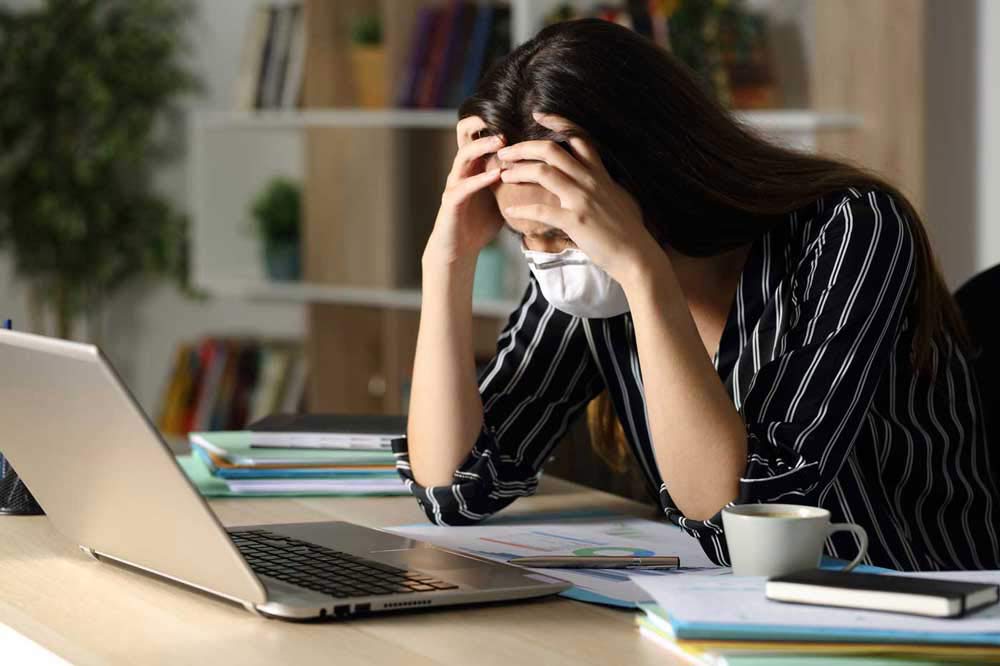 Exhausted woman at her home office desk