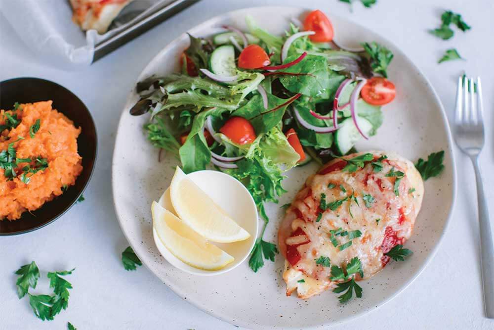 A plate of chicken parmigiana and a green salad