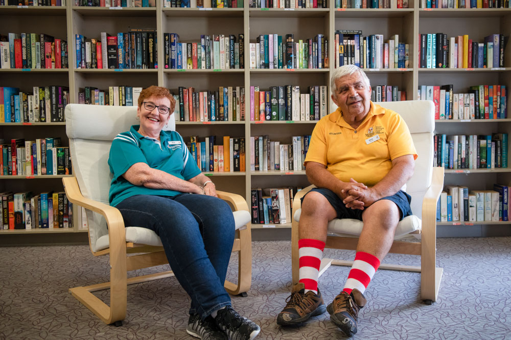 Man and woman sitting in library smiling