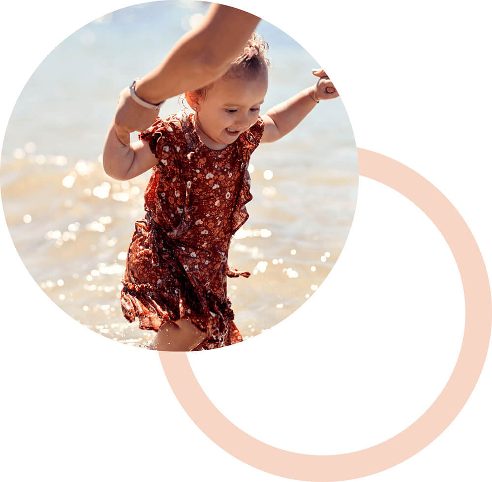 small child with feet in the ocean